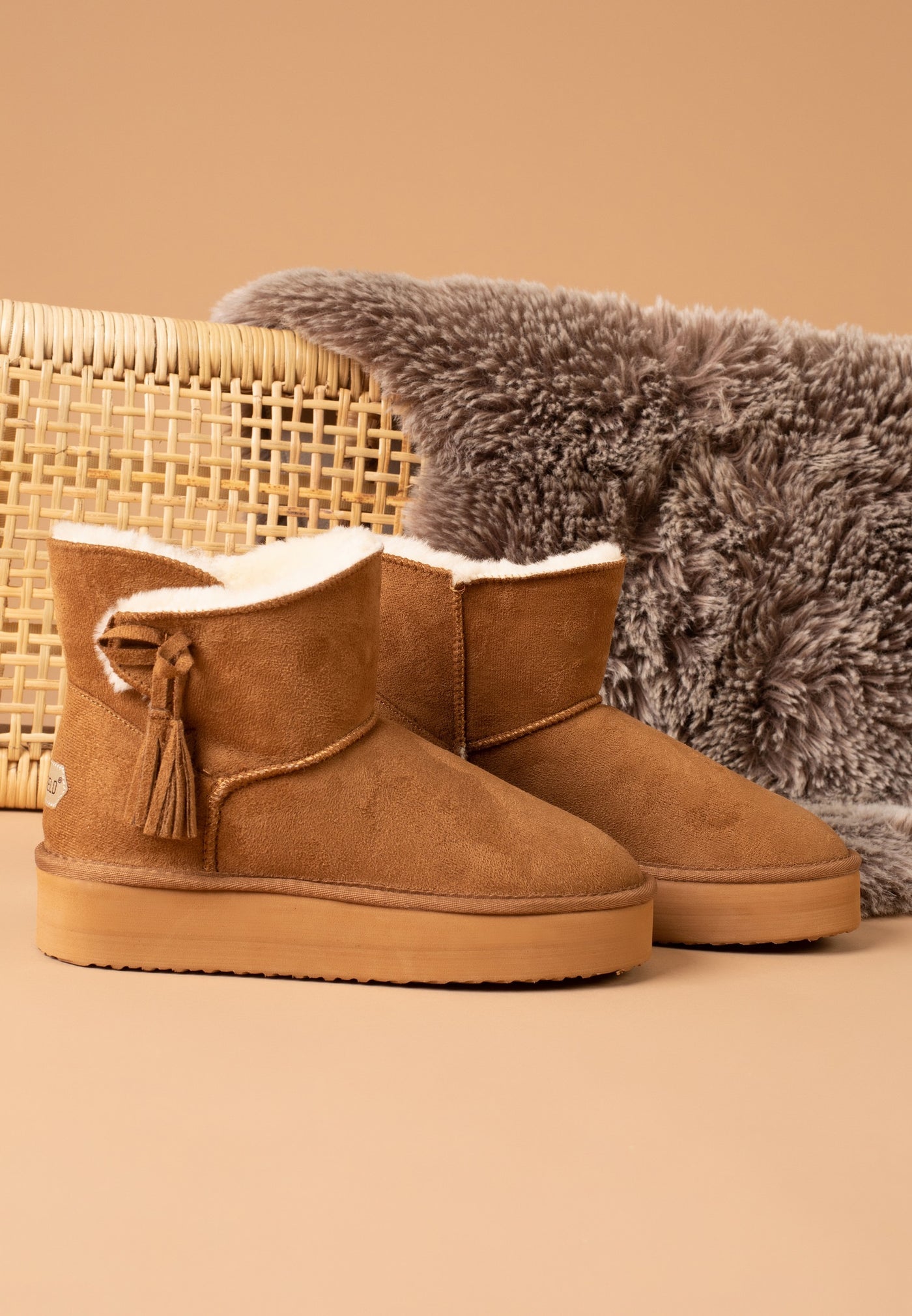 Paire de bottines fourrées Curry camel de trois-quarts près d'un plaid moelleux
