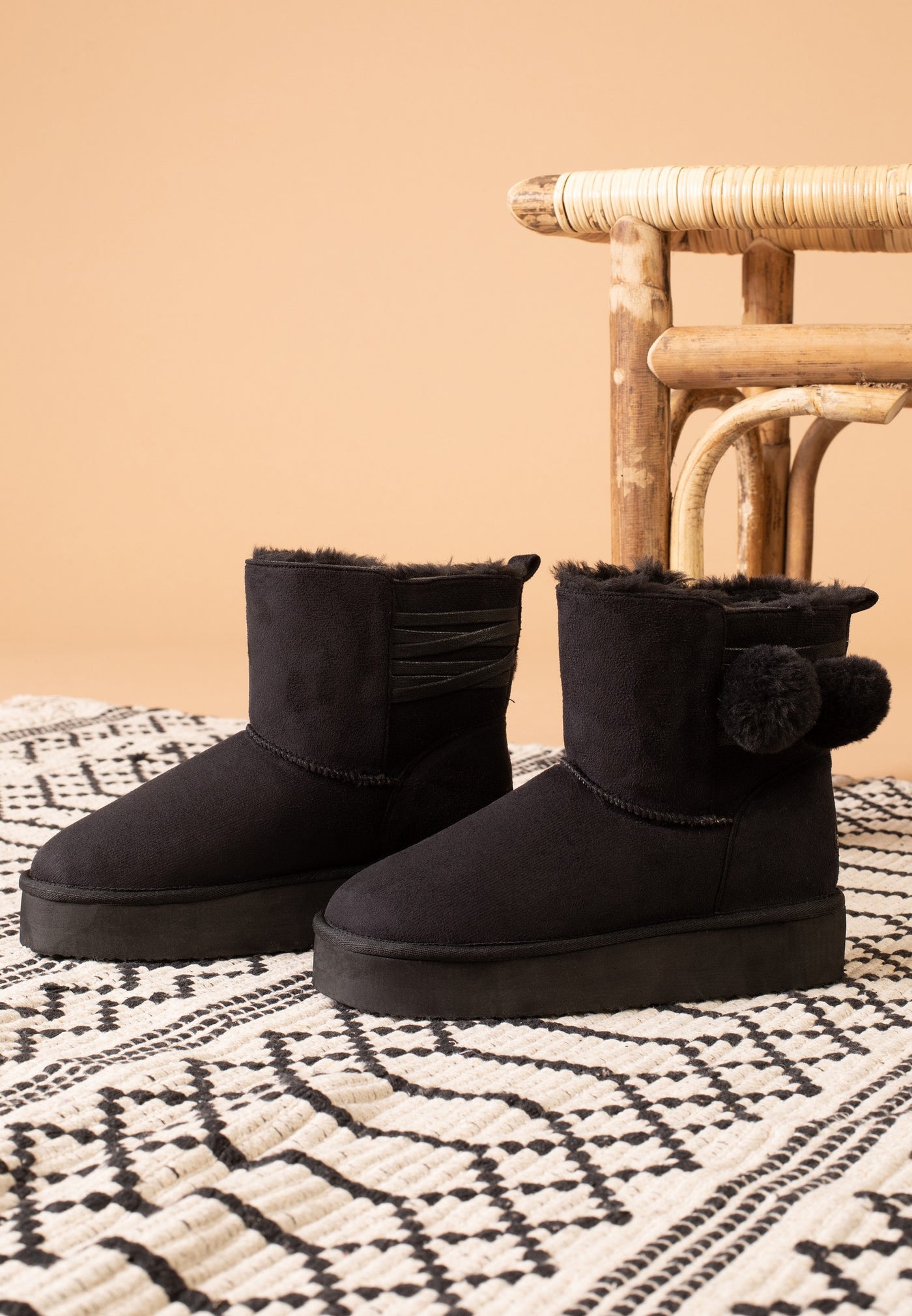 Paire de bottines fourrées Winnipeg noires posée sur un tapis, vue de trois-quarts