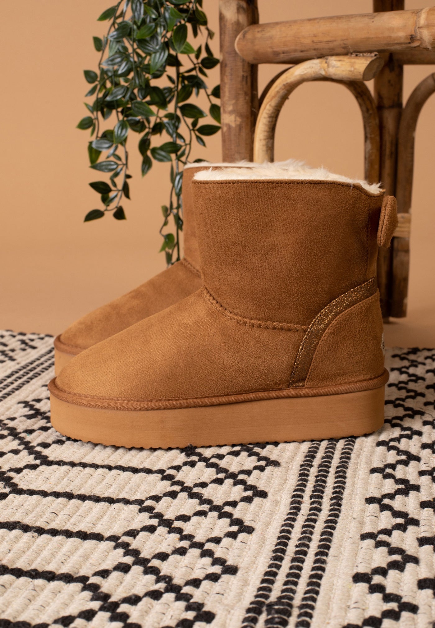 Bottine fourrée Champlain camel de profil sur un tapis tissé écru et noir