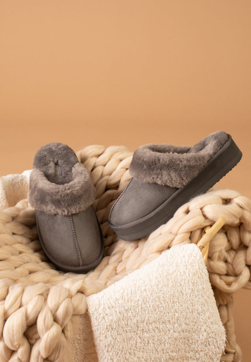 Paire de chaussons fourrés Emilija anthracite vue de profil dans un panier tressé