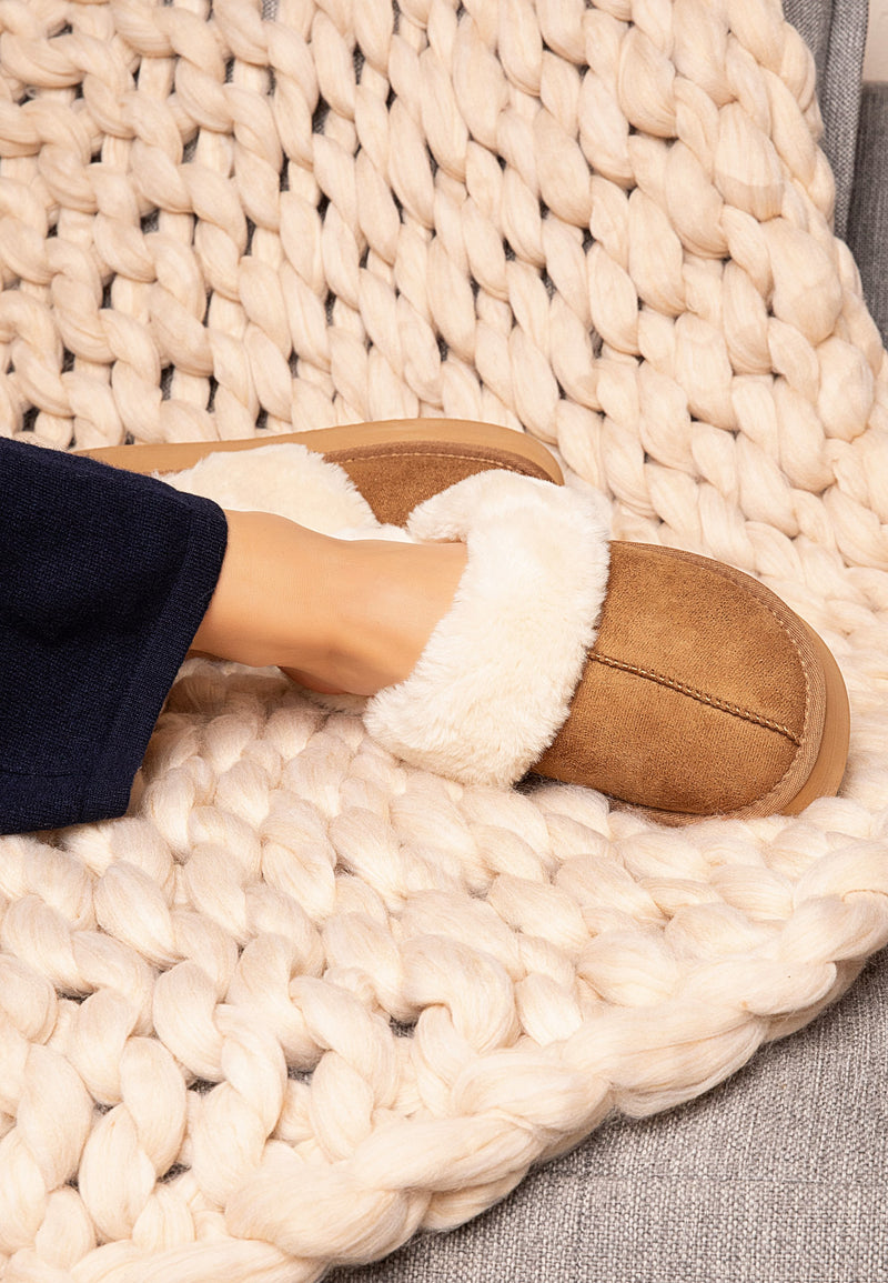 Chausson fourré camel Sleepers Emilija de profil sur un plaid tressé écru clair