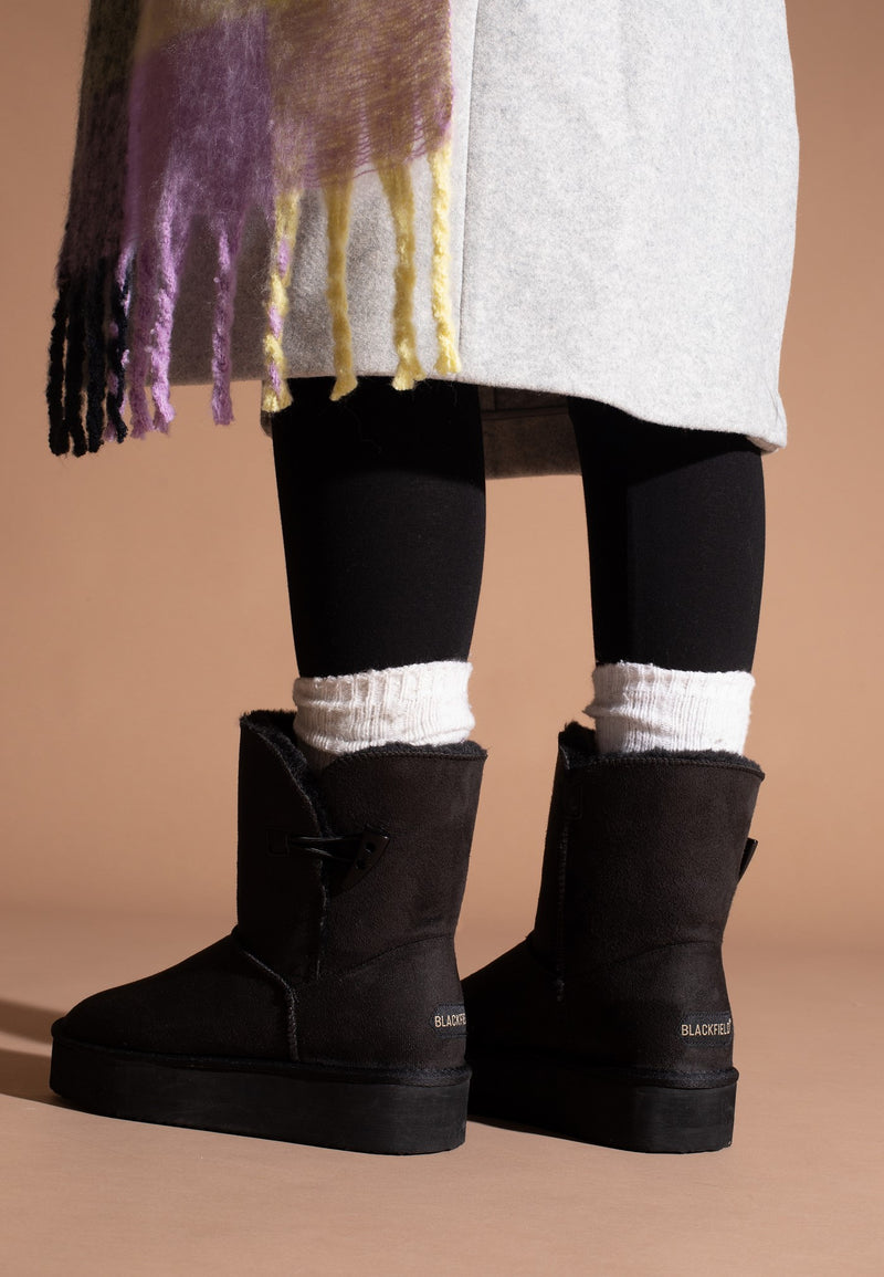 Bottines fourrées Anais noires portées de dos, chaussettes blanches roulées au bord