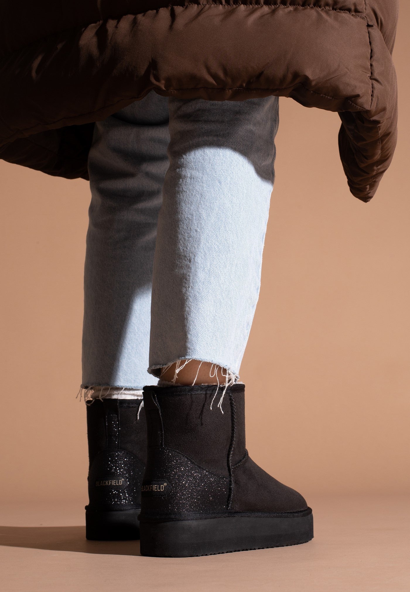 Bottines fourrées Casablanca noires portées de dos, logos dorés sur les contreforts