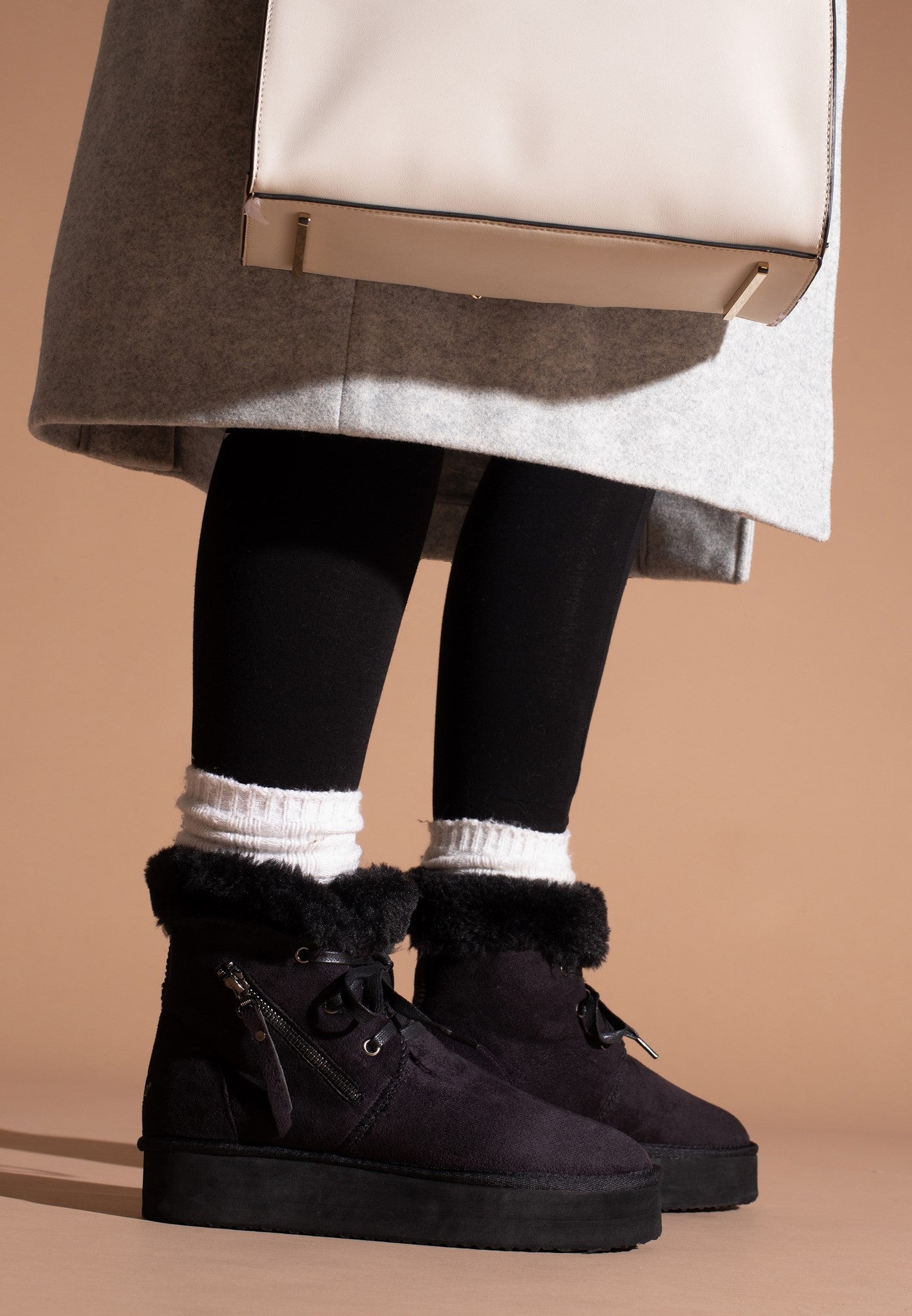 Bottines à plateforme fourrées Celia noires portées avec un collant noir et des socquettes