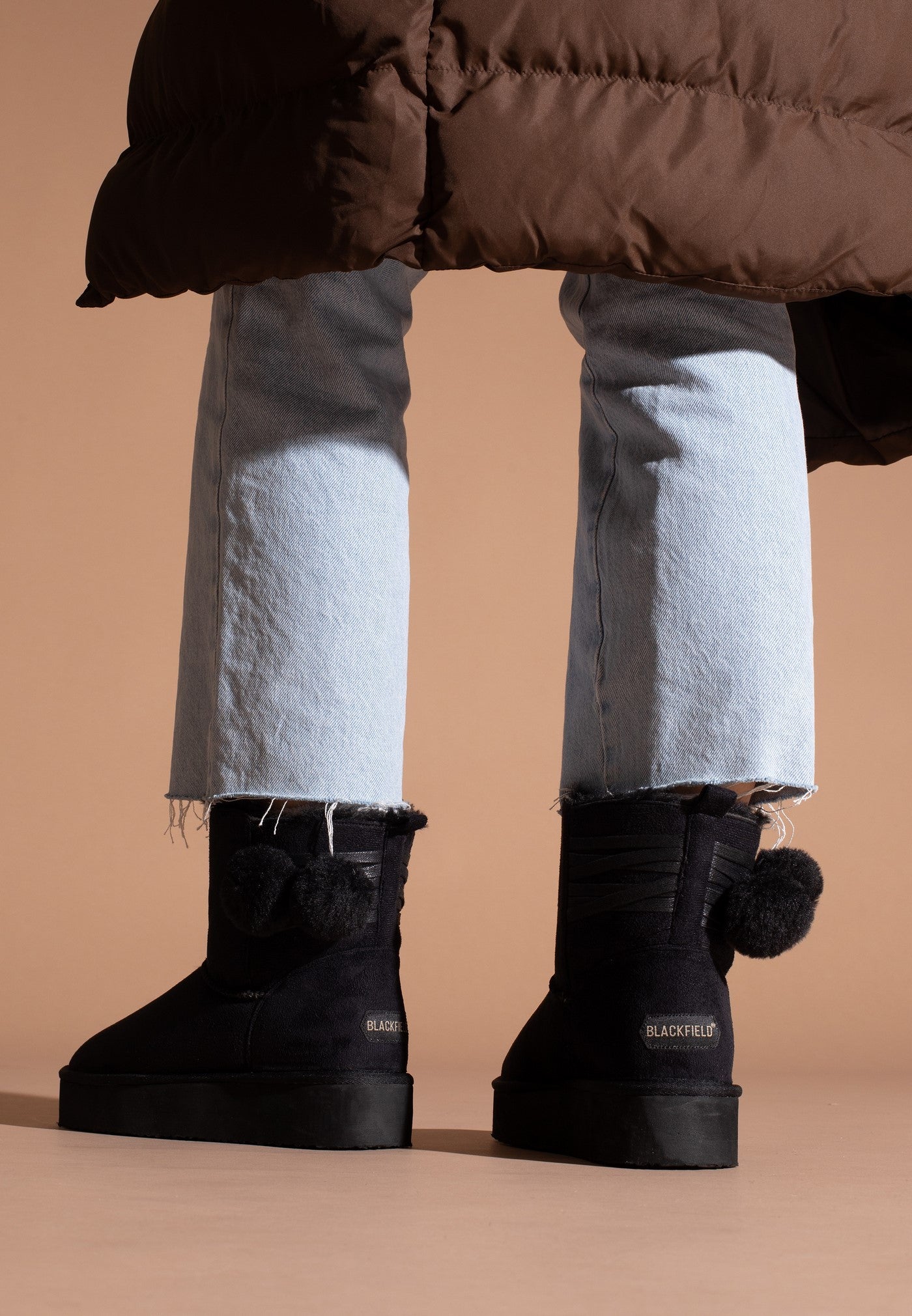 Bottines fourrées Winnipeg noires vues de dos aux pieds, rubans croisés et pompons