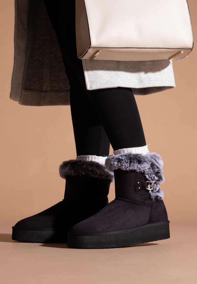 Bottines fourrées Reindeer noires portées avec un collant noir et des socquettes