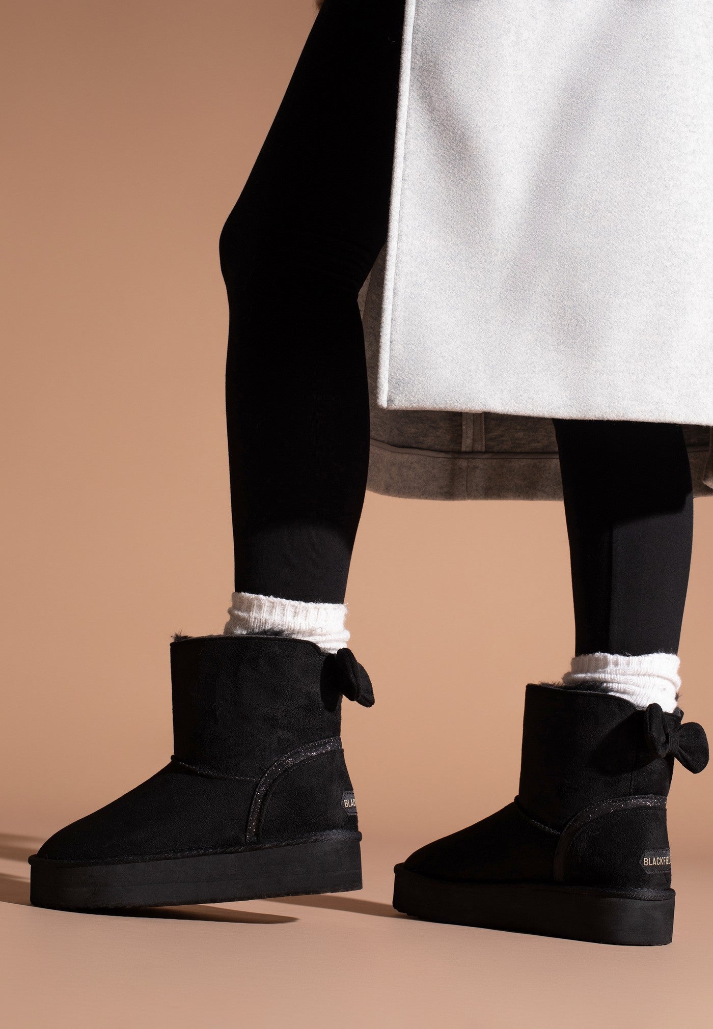 Bottines fourrées Champlain noires portées avec un collant noir et des socquettes crème