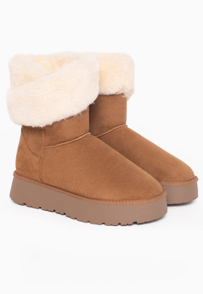 Deux bottines fourrées Barbara camel posées de trois-quarts, larges revers crème rabattus