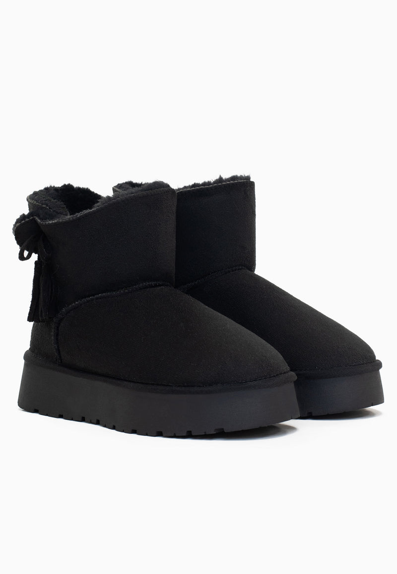 Deux bottines fourrées Curry noires de trois-quarts, glands à franges sur le côté
