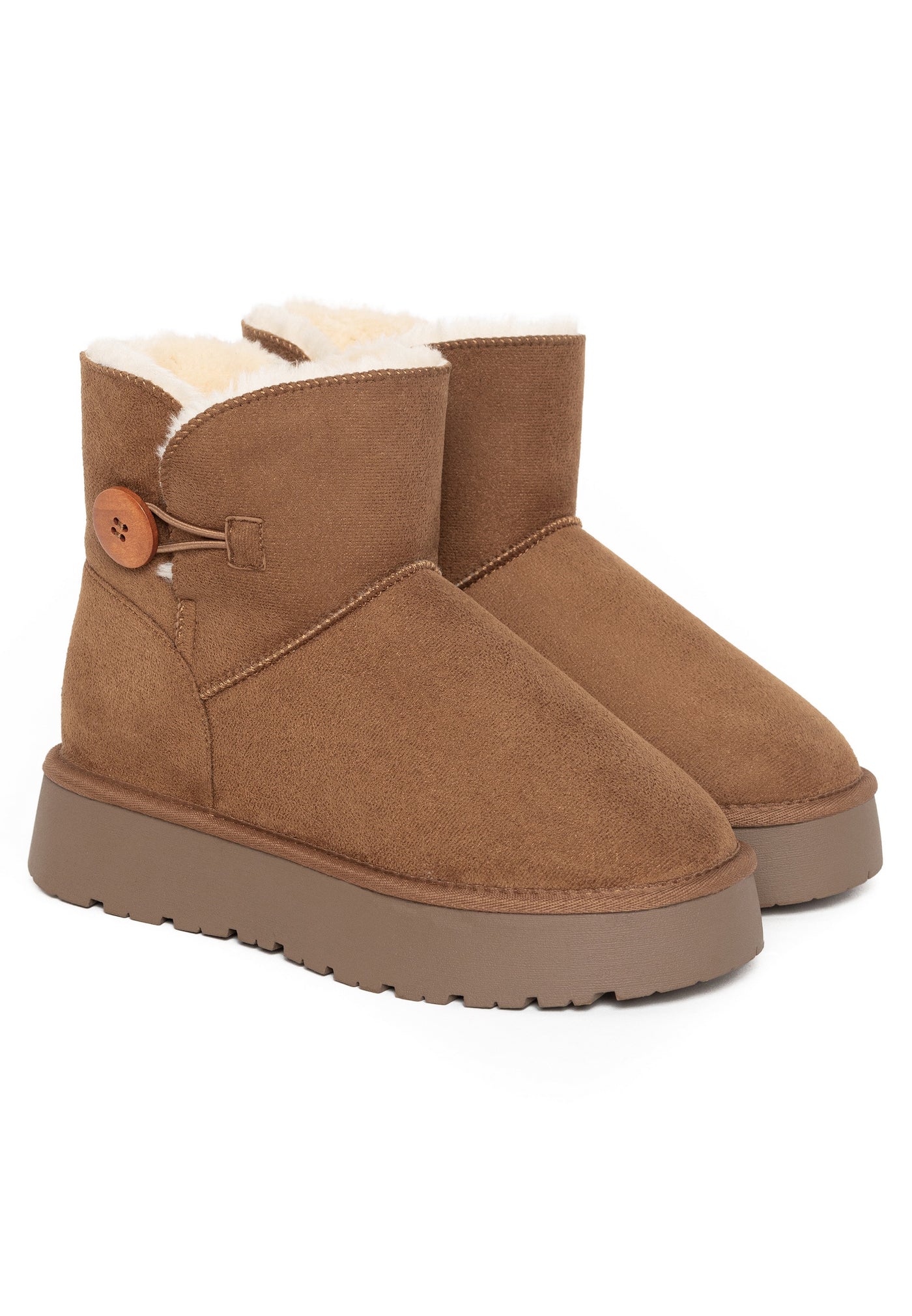 Deux bottines fourrées Clair camel posées de trois-quarts, bouton de bois au col