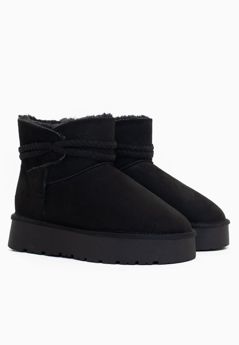 Les deux bottines fourrées Mergie noires de profil, lien tressé ton sur ton au col