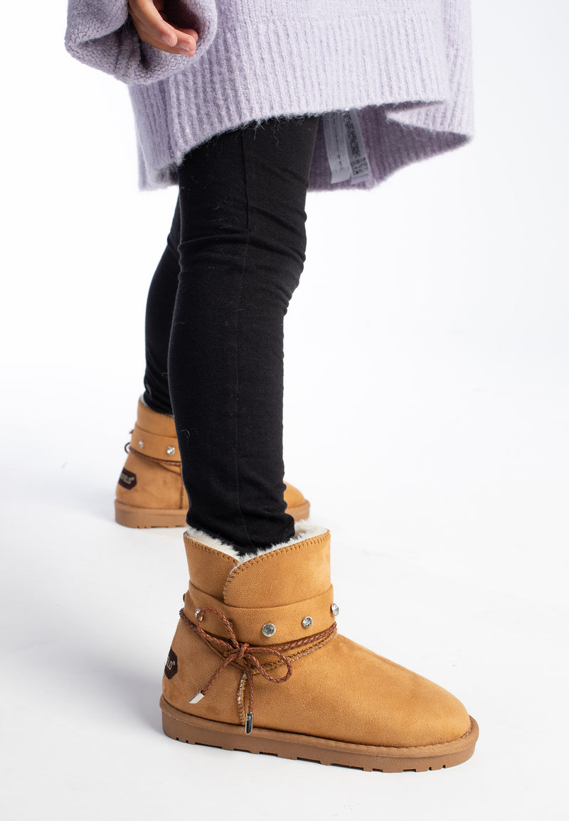 Bottines fourrées Sutton camel portées de profil avec un pull lilas et un jean noir