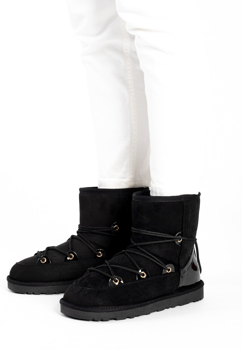 Bottines fourrées Rose noires portées avec un jean blanc, laçage doré sur le cou-de-pied