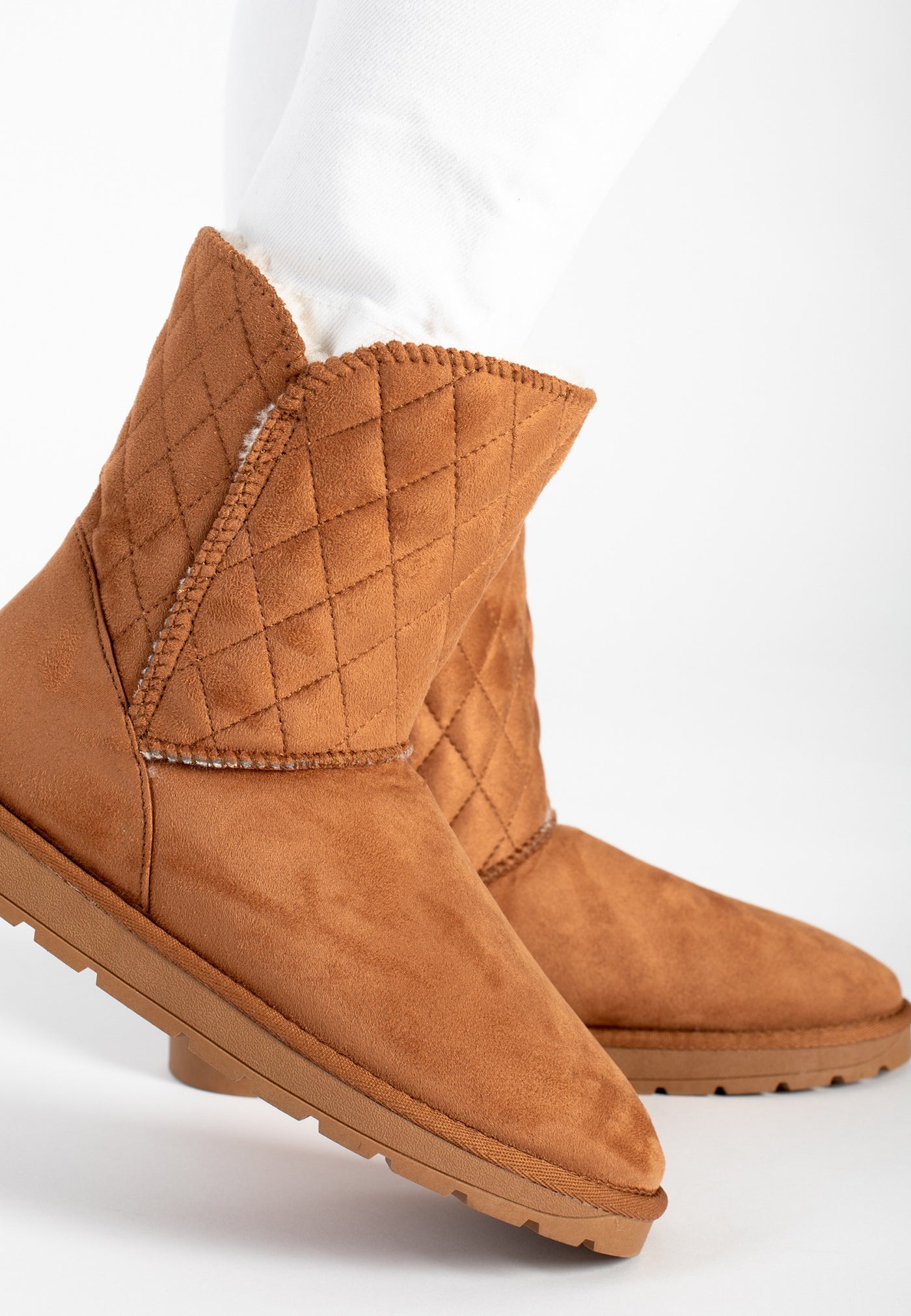 Bottines fourrées Maelis camel portées sous un pantalon blanc, vues de trois-quarts