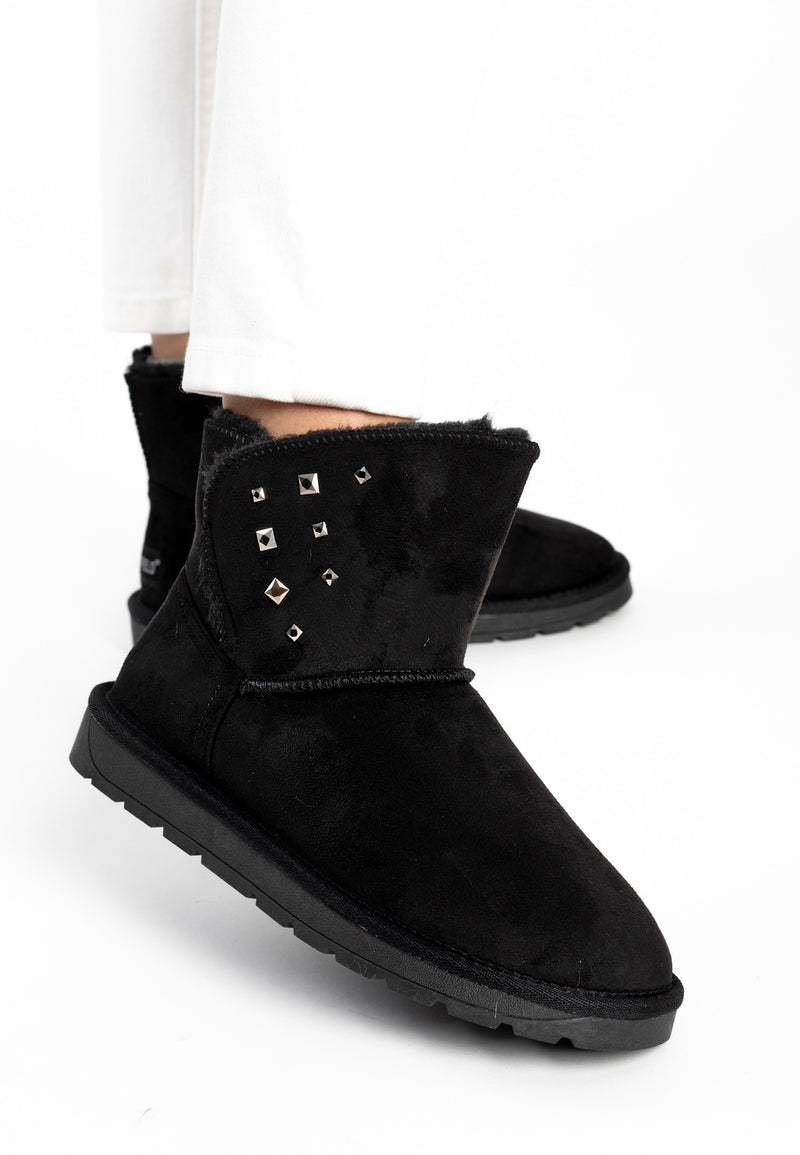 Sous un pantalon blanc, bottines fourrées Lady noires portées, strass en losange