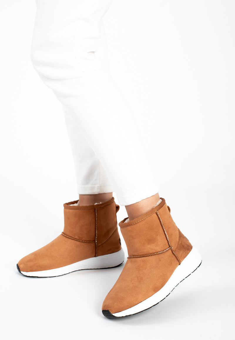 Bottines fourrées Courtes Josie camel portées avec un pantalon blanc et semelle claire