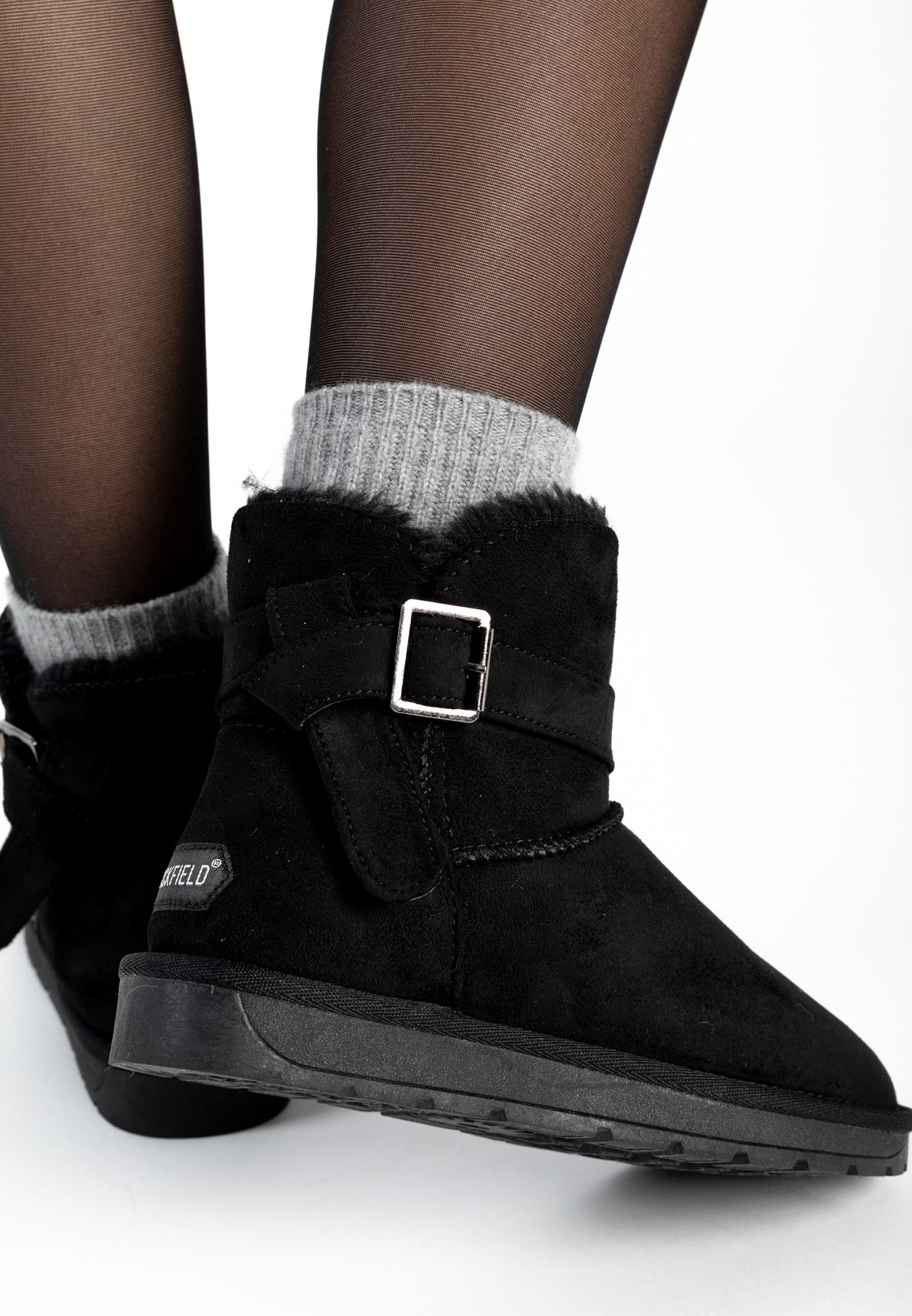 Bottines fourrées Eualie noires portées avec des chaussettes grises, boucle argentée