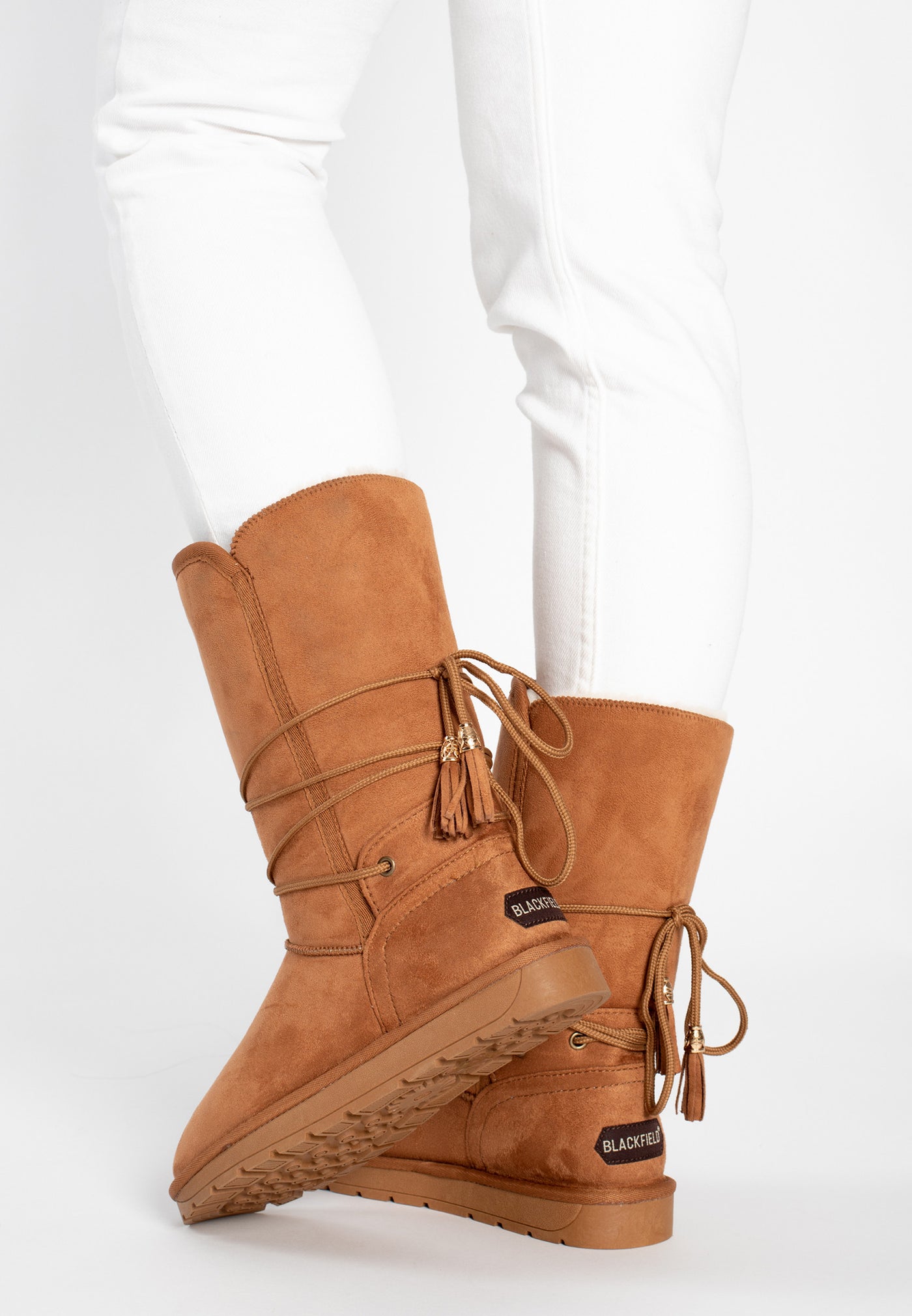 Bottes fourrées Eowin camel portées avec un jean blanc, glands dorés en mouvement