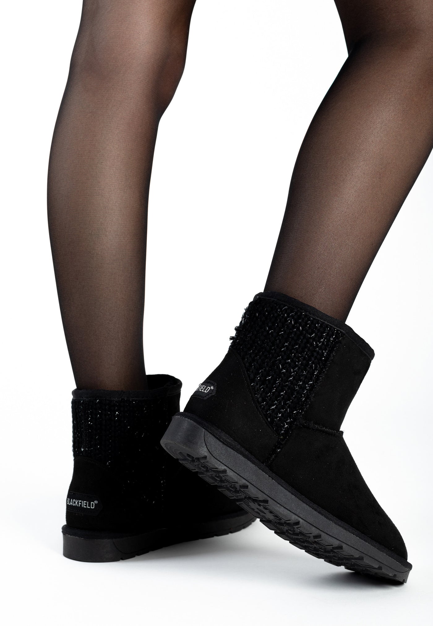 Bottines fourrées Davia noires portées avec des collants transparents, semelle visible