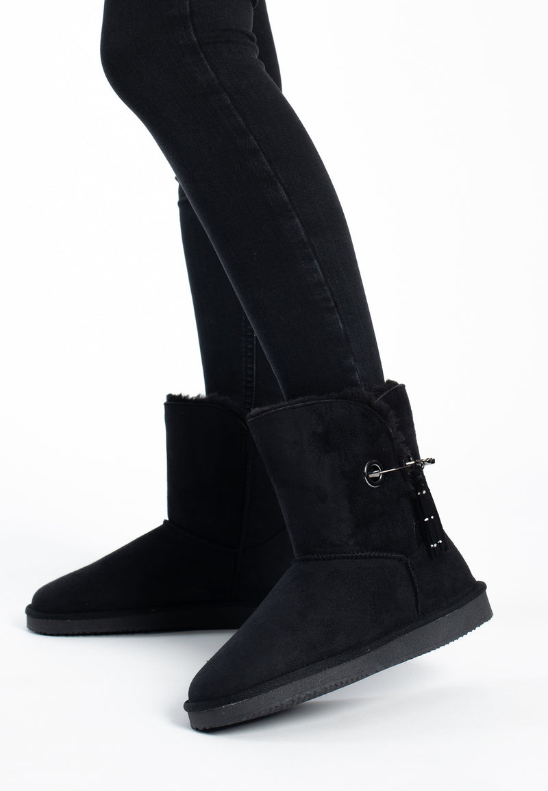 Vue de trois-quarts sur les bottines fourrées Clair noires, œillets dorés sur fond noir