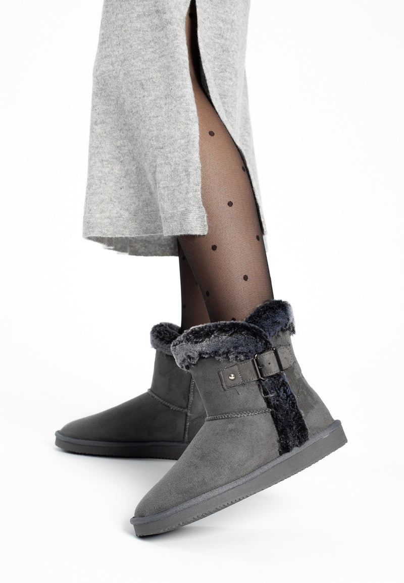 Paire de bottines fourrées Anthabasca gris foncé portées sous une jupe grise en maille