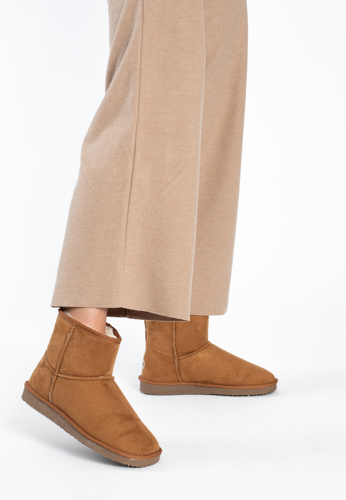 Paire de bottines fourrées Princesse camel en marche, pantalon large beige au-dessus
