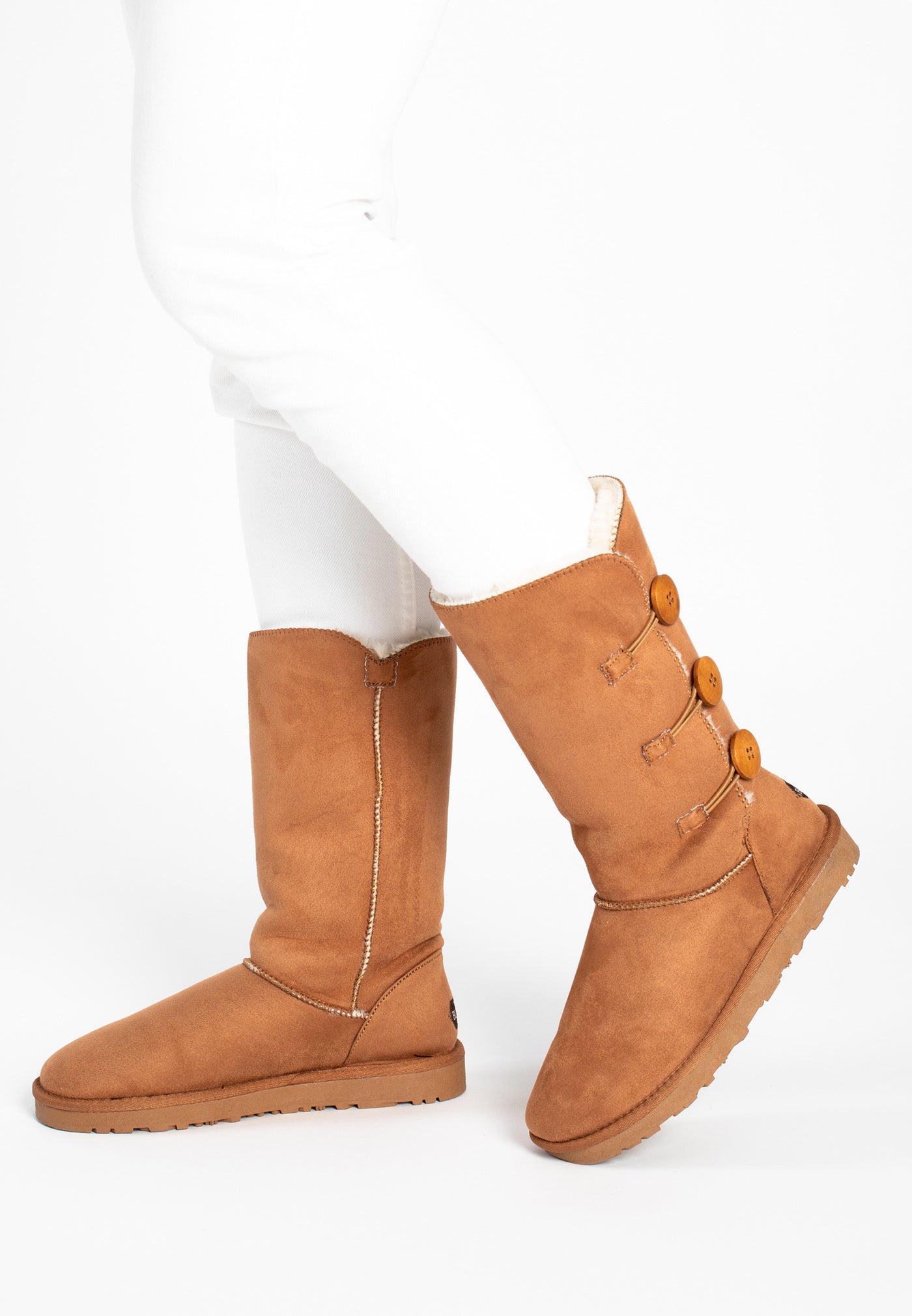 Bottes fourrées Flocon camel portées avec un pantalon blanc, trois boutons de bois visibles