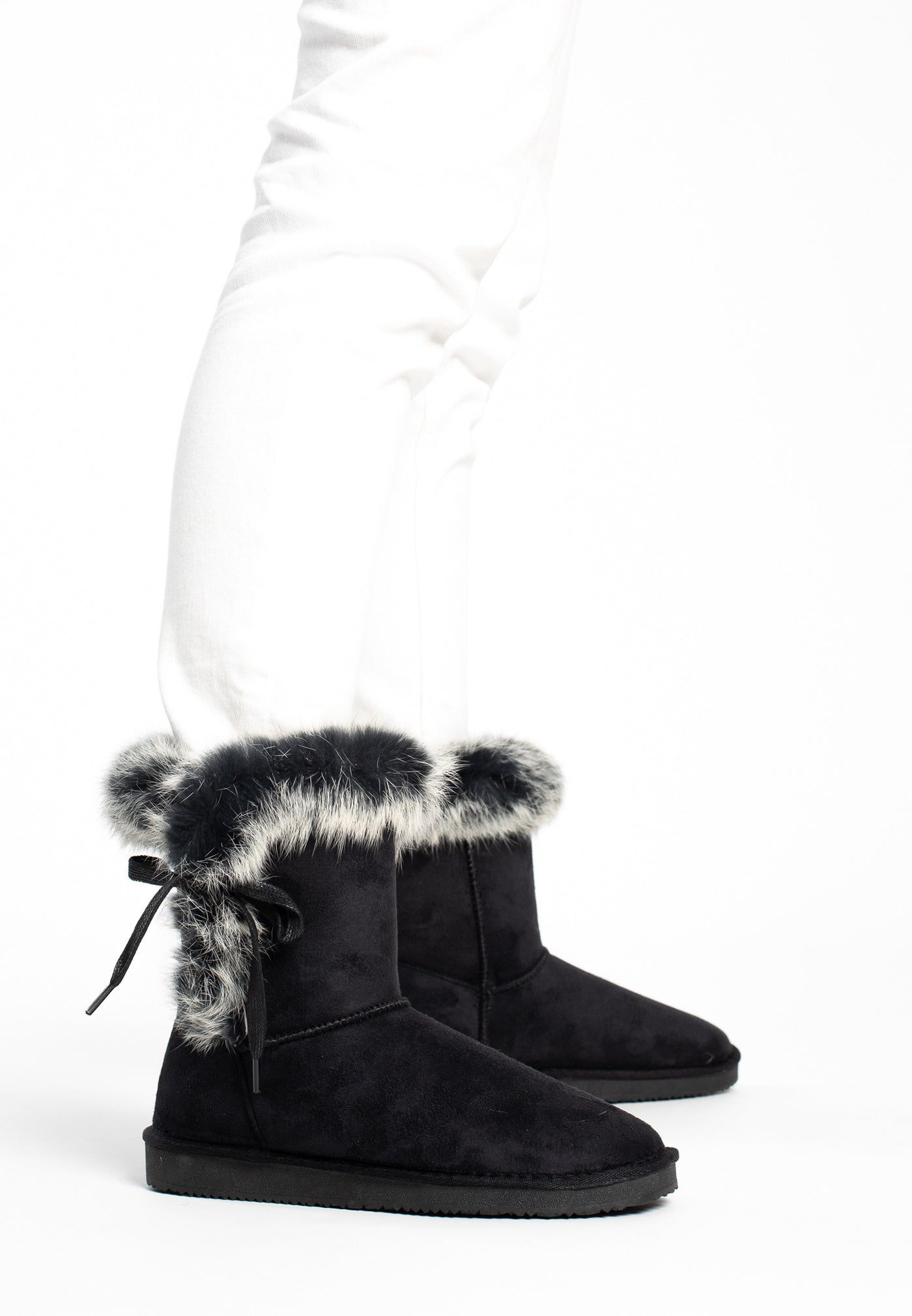 Bottines fourrées Chuckson noires portées avec un pantalon blanc, cols chinés gris