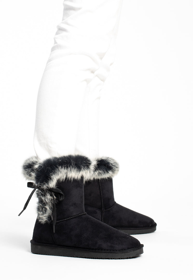 Bottines fourrées Chuckson noires portées avec un pantalon blanc, cols chinés gris