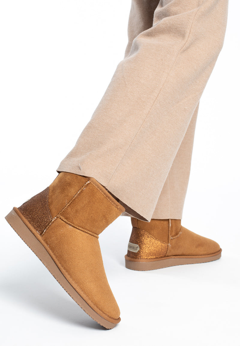 Bottines fourrées Casablanca camel portées en marche avec un pantalon large beige