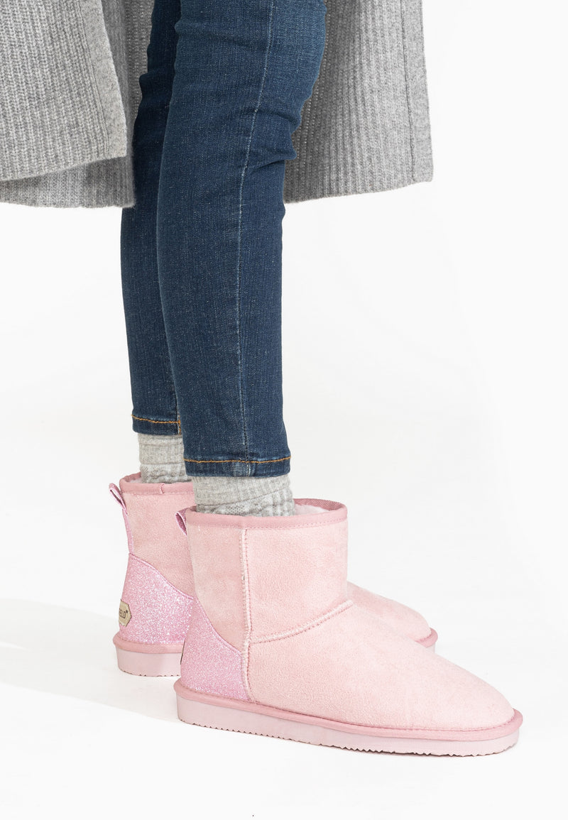 Bottines fourrées Casablanca roses portées avec un jean brut et un long gilet gris