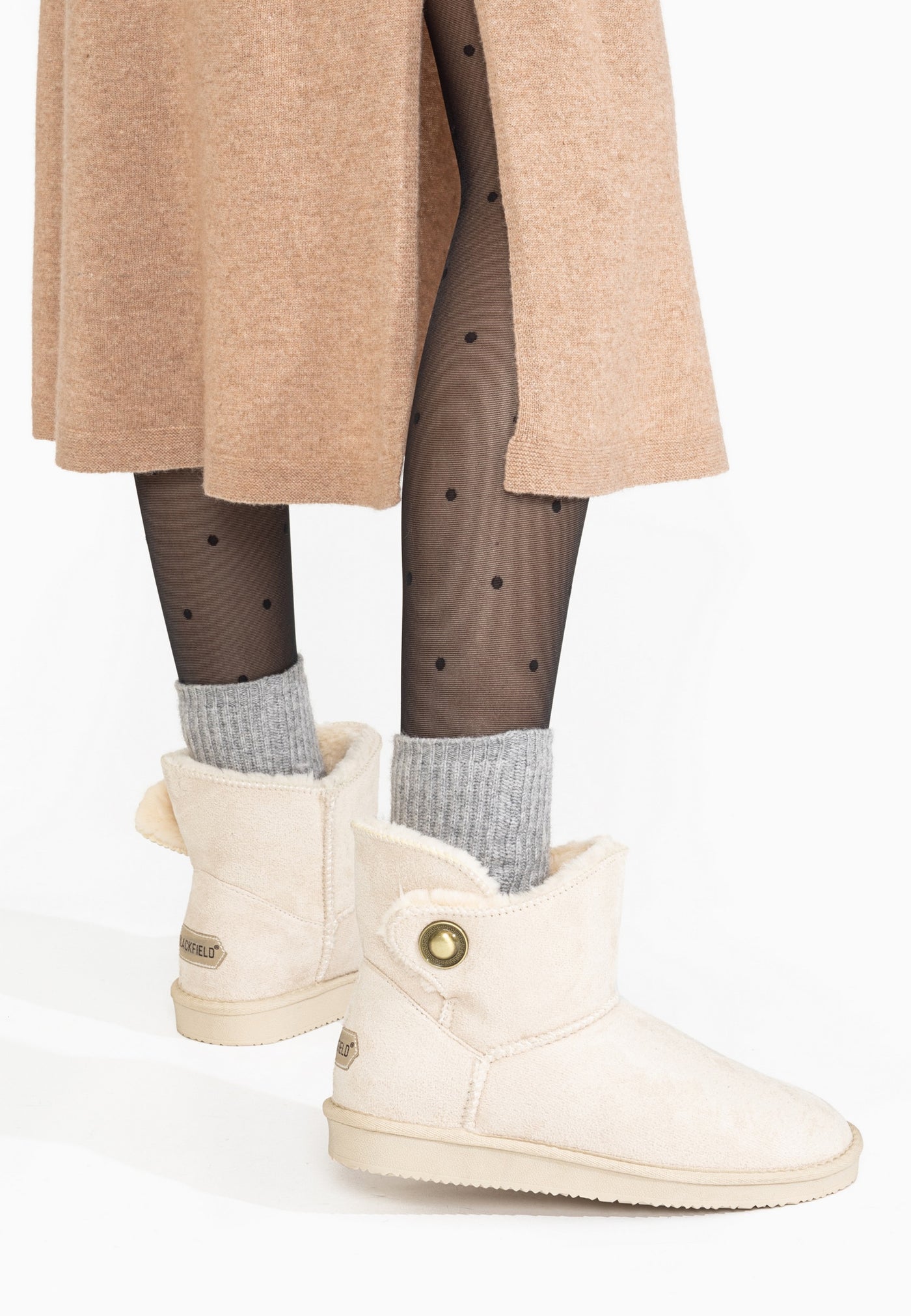 Bottines fourrées Cayuga naturel portées de dos, étiquette dorée cousue au talon