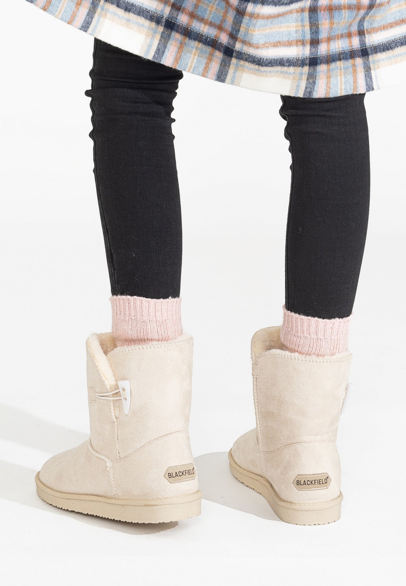 Bottines fourrées Anais naturel portées de dos, manteau à carreaux et chaussettes roses