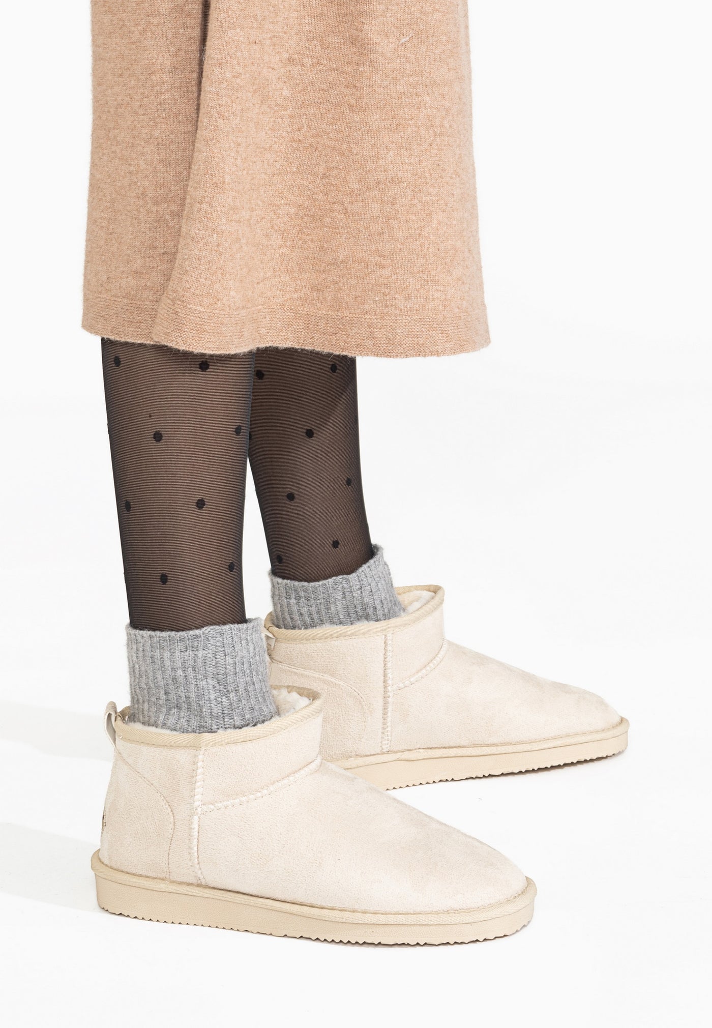 Bottines fourrées basses Milli écru portées avec des chaussettes grises en côtes qui dépassent