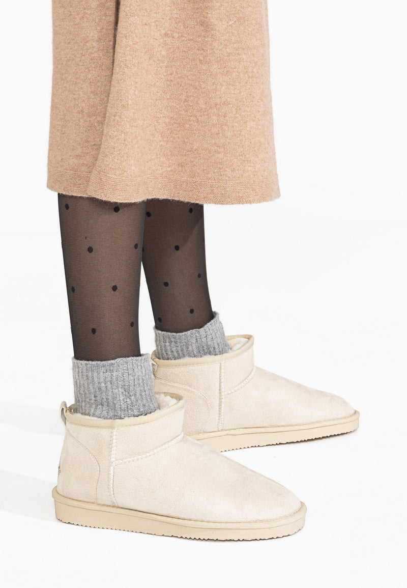 Bottines fourrées basses Milli écru portées avec des chaussettes grises en côtes qui dépassent