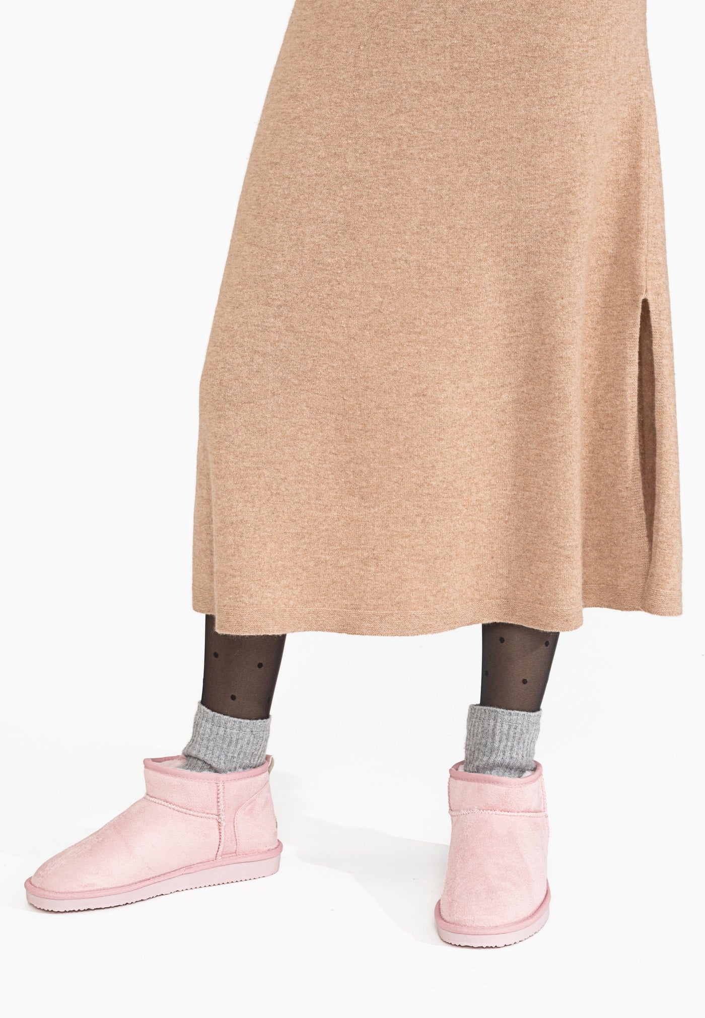 Bottines fourrées Mini Milli roses portées avec des chaussettes grises et une jupe camel