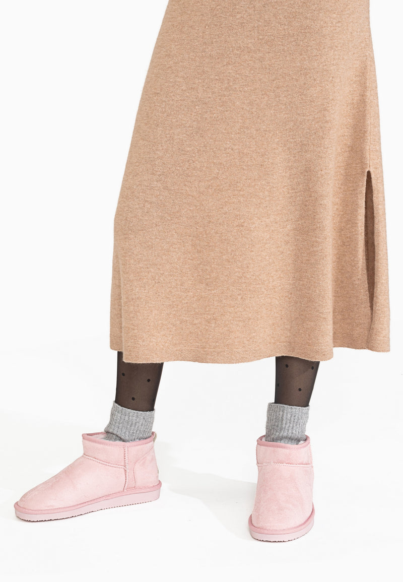 Bottines fourrées Mini Milli roses portées avec des chaussettes grises et une jupe camel