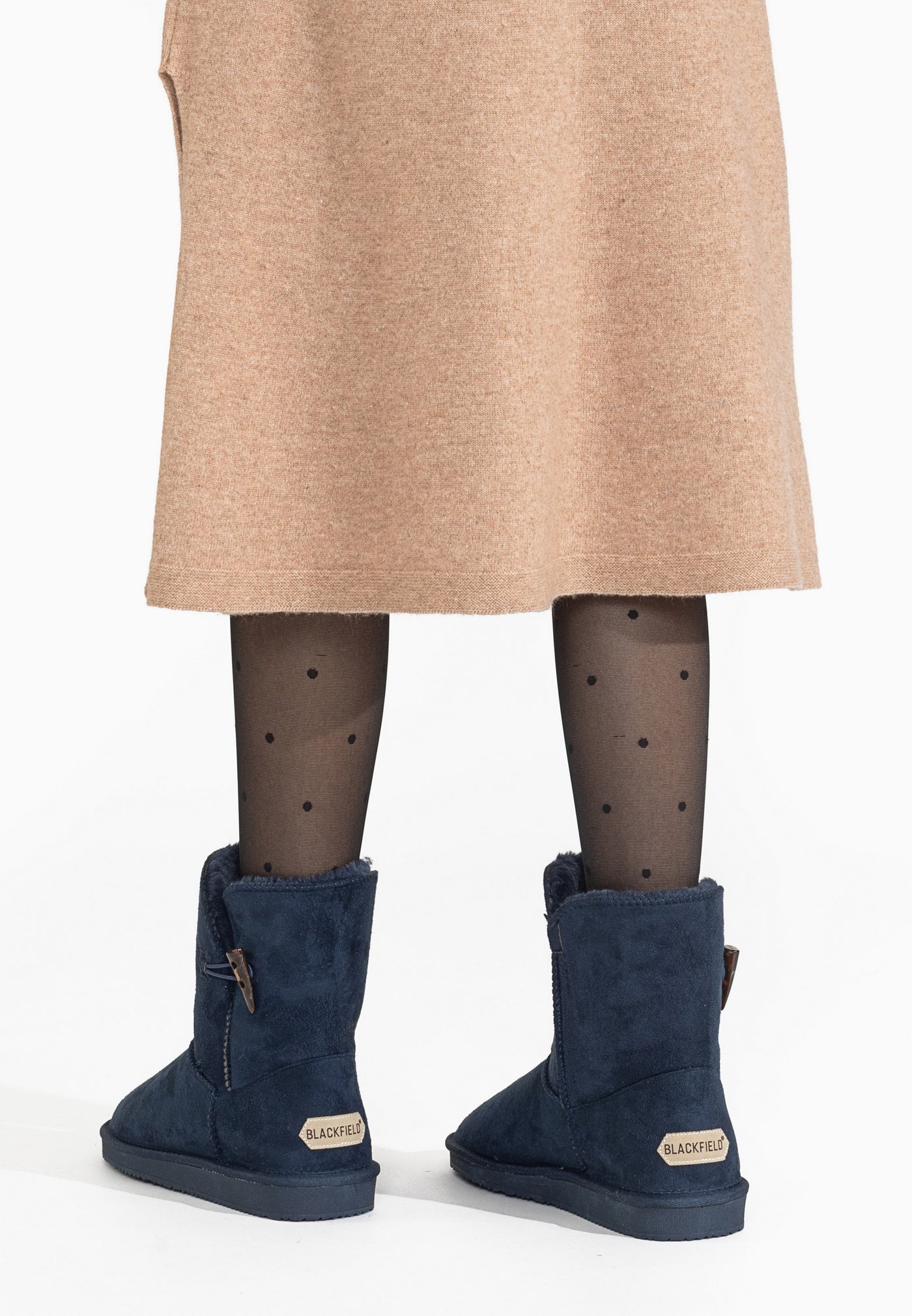 Bottines fourrées Anais marine portées de dos, jupe camel et collants noirs à pois