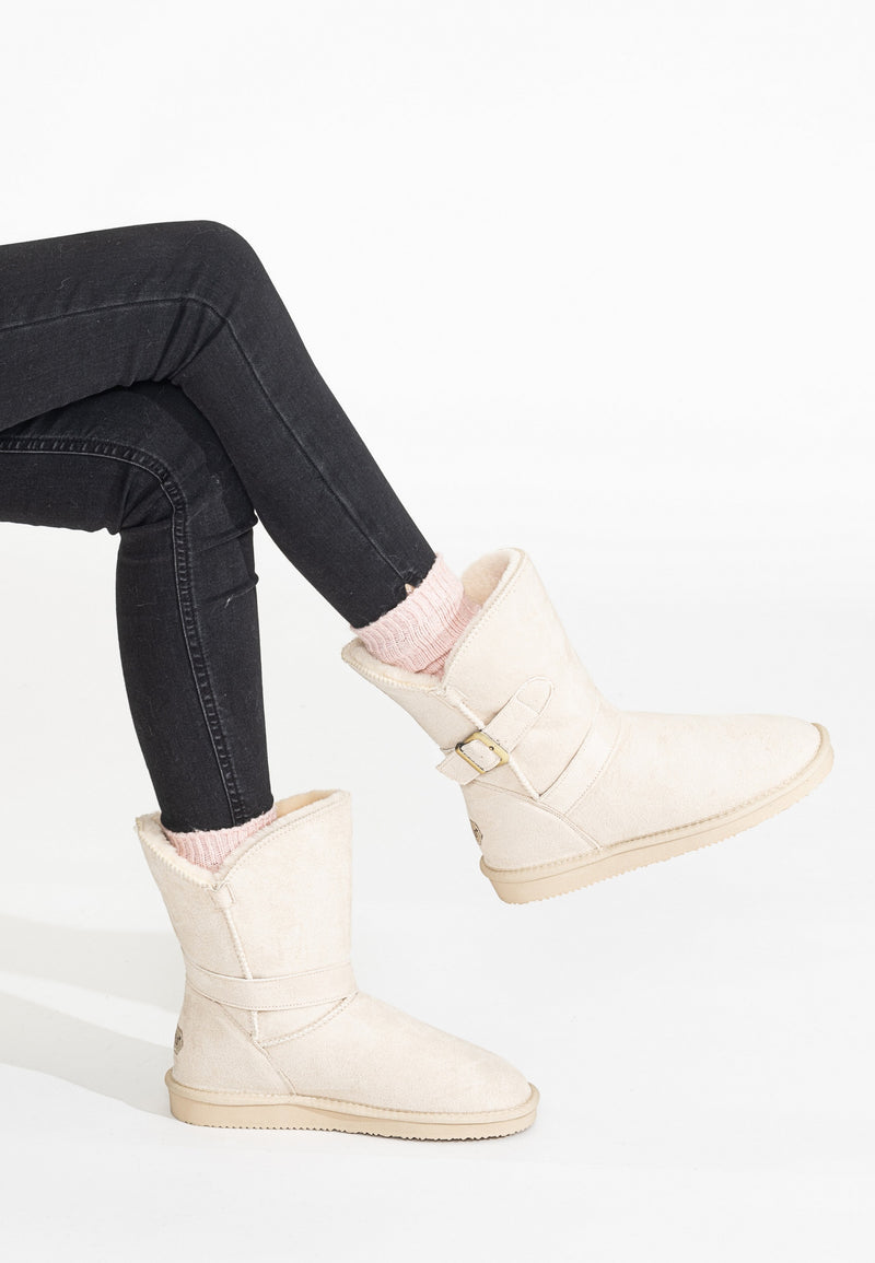 Bottines fourrées Eden naturel portées avec un jean noir, un pied relevé