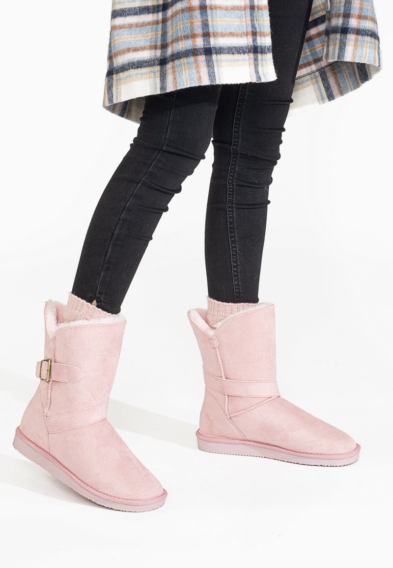 Bottines fourrées Eden rose portées avec un legging noir, boucles laiton visibles