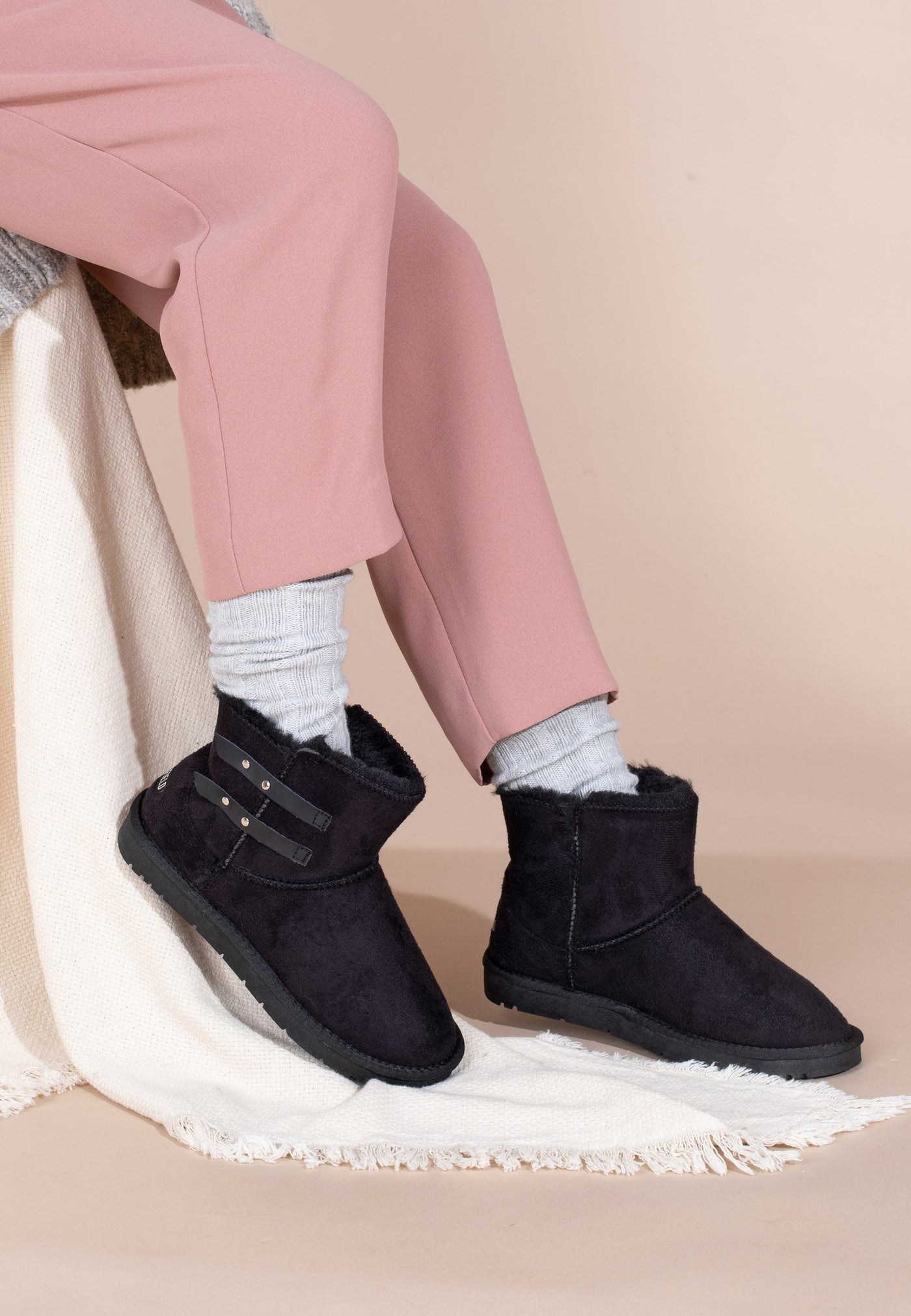 Bottines fourrées Barry noires portées de trois-quarts, brides cloutées visibles sur la tige