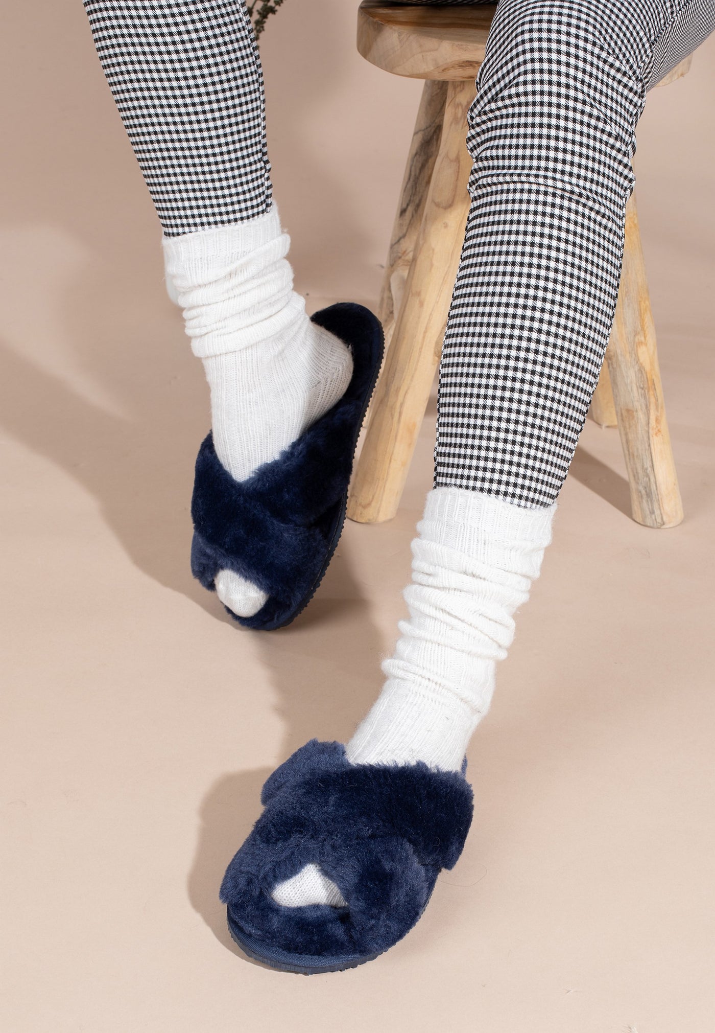 Chaussons fourrés Fanny marine portés avec un pantalon pied-de-poule noir et blanc