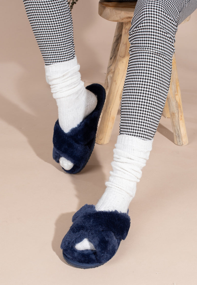 Chaussons fourrés Fanny marine portés avec un pantalon pied-de-poule noir et blanc