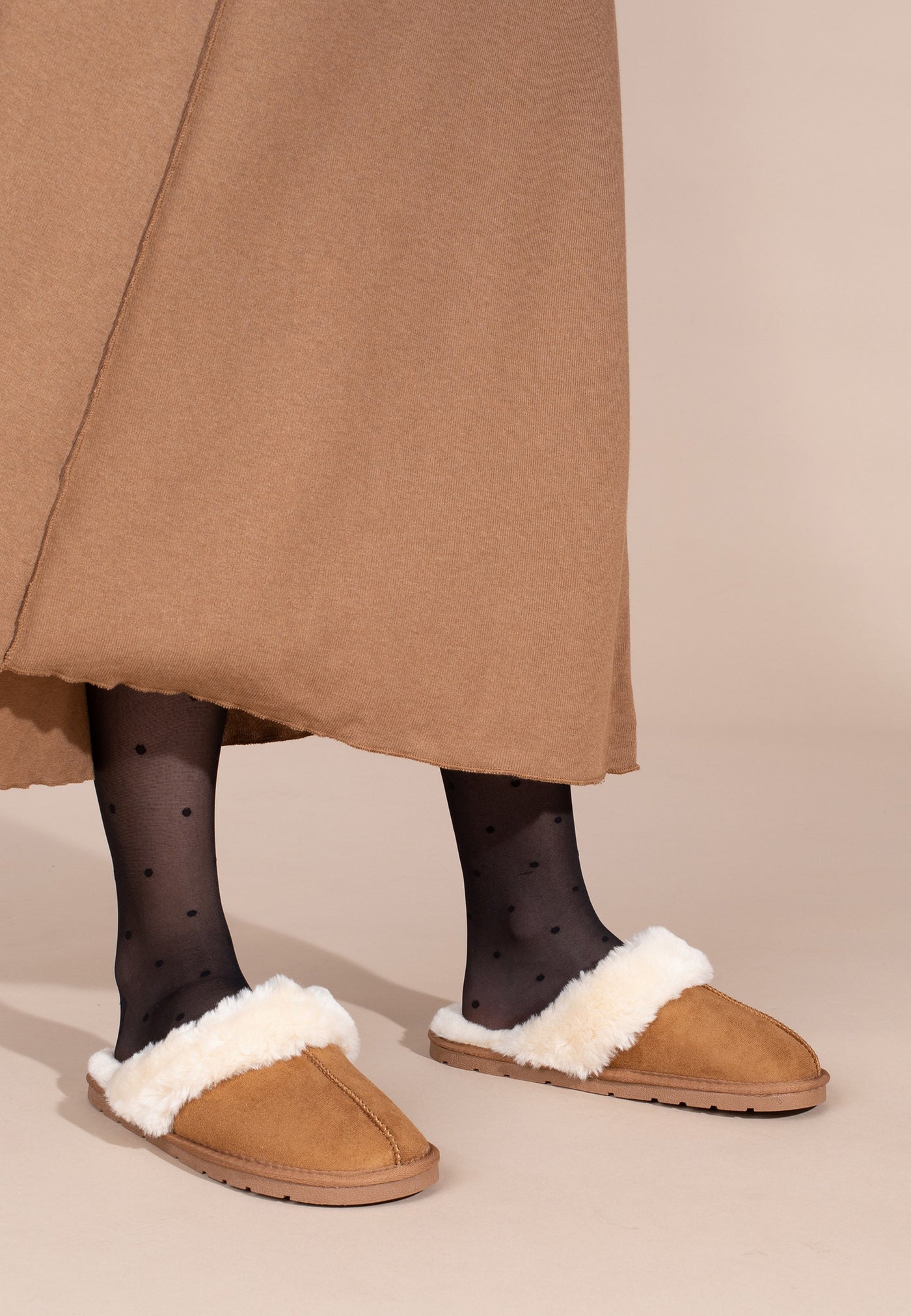 Vus de profil aux pieds, chaussons fourrés Sleepers Emilija camel et collants à pois