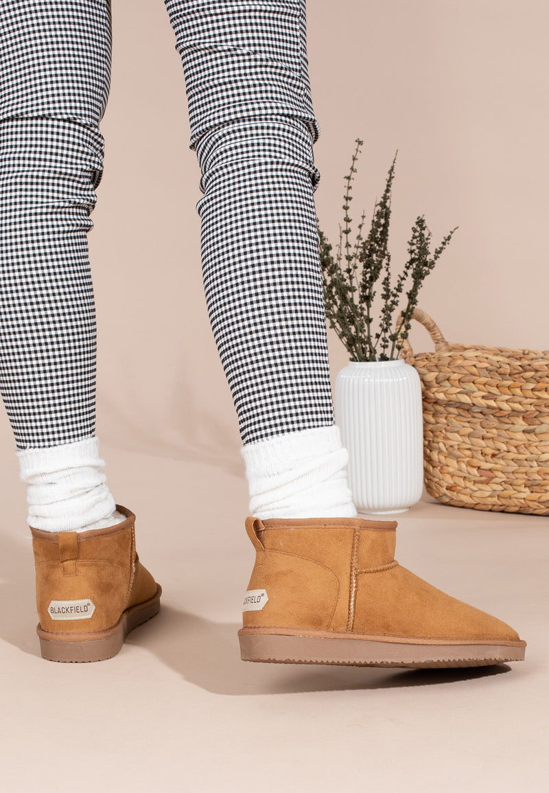 Talons des bottines fourrées Mini Milli camel vus de dos, chaussettes blanches froissées