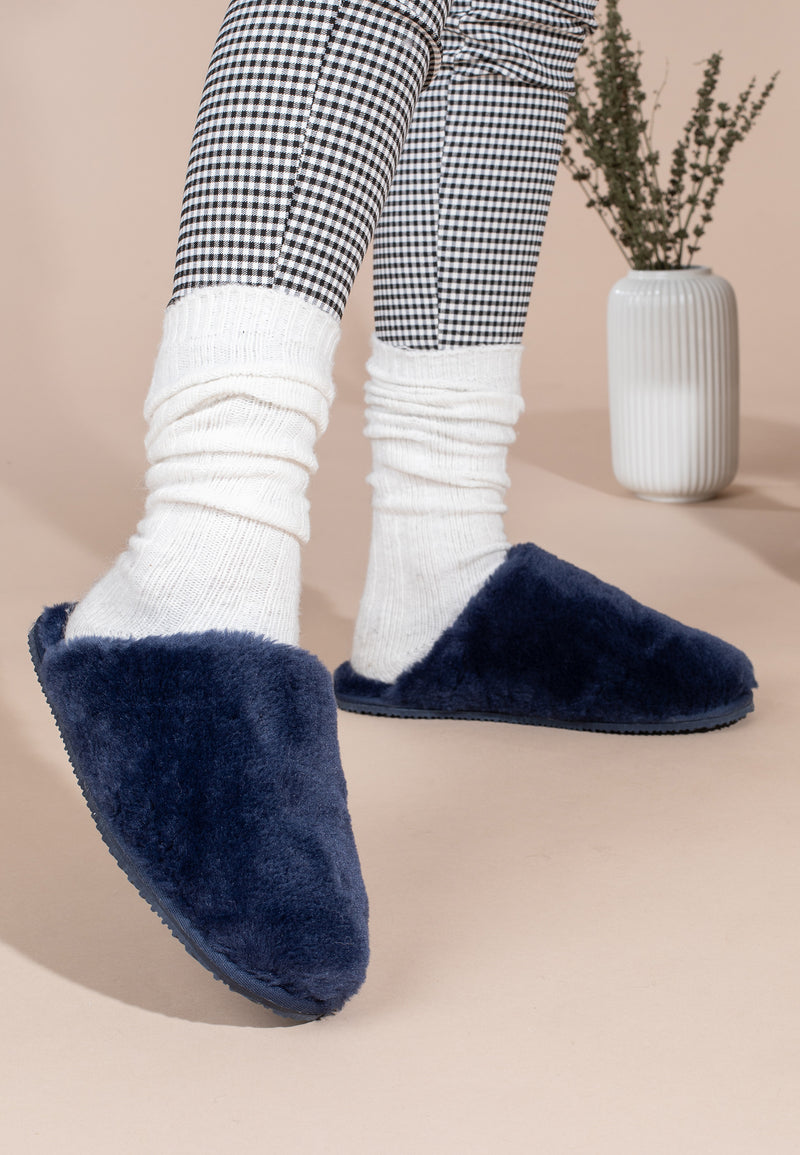 Chaussons fourrés Fraya marine portés avec chaussettes blanches et pantalon à carreaux