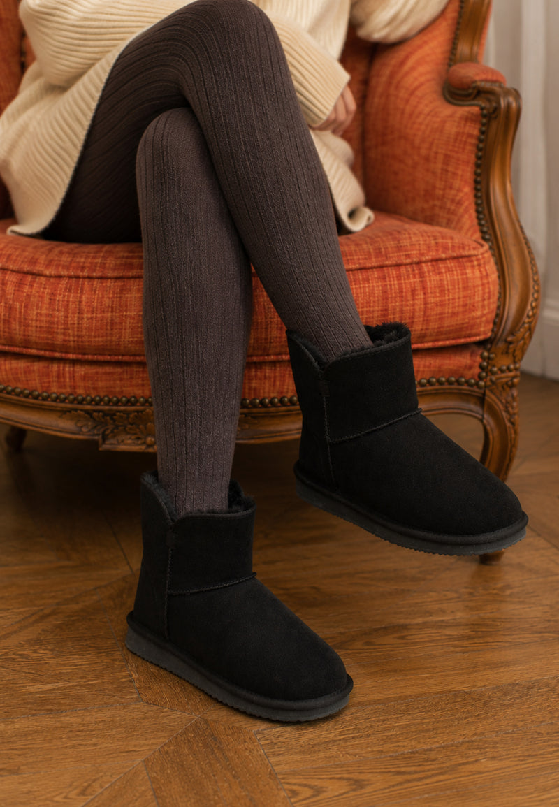 Bottines fourrées Bellevue noires portées assise, collants côtelés et fauteuil orange