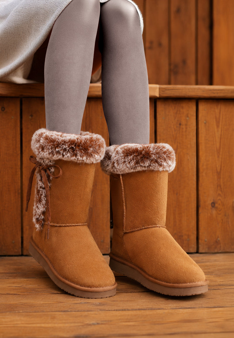 Bottines fourrées Chuckson camel portées sur un banc en bois, cols chinés repliés