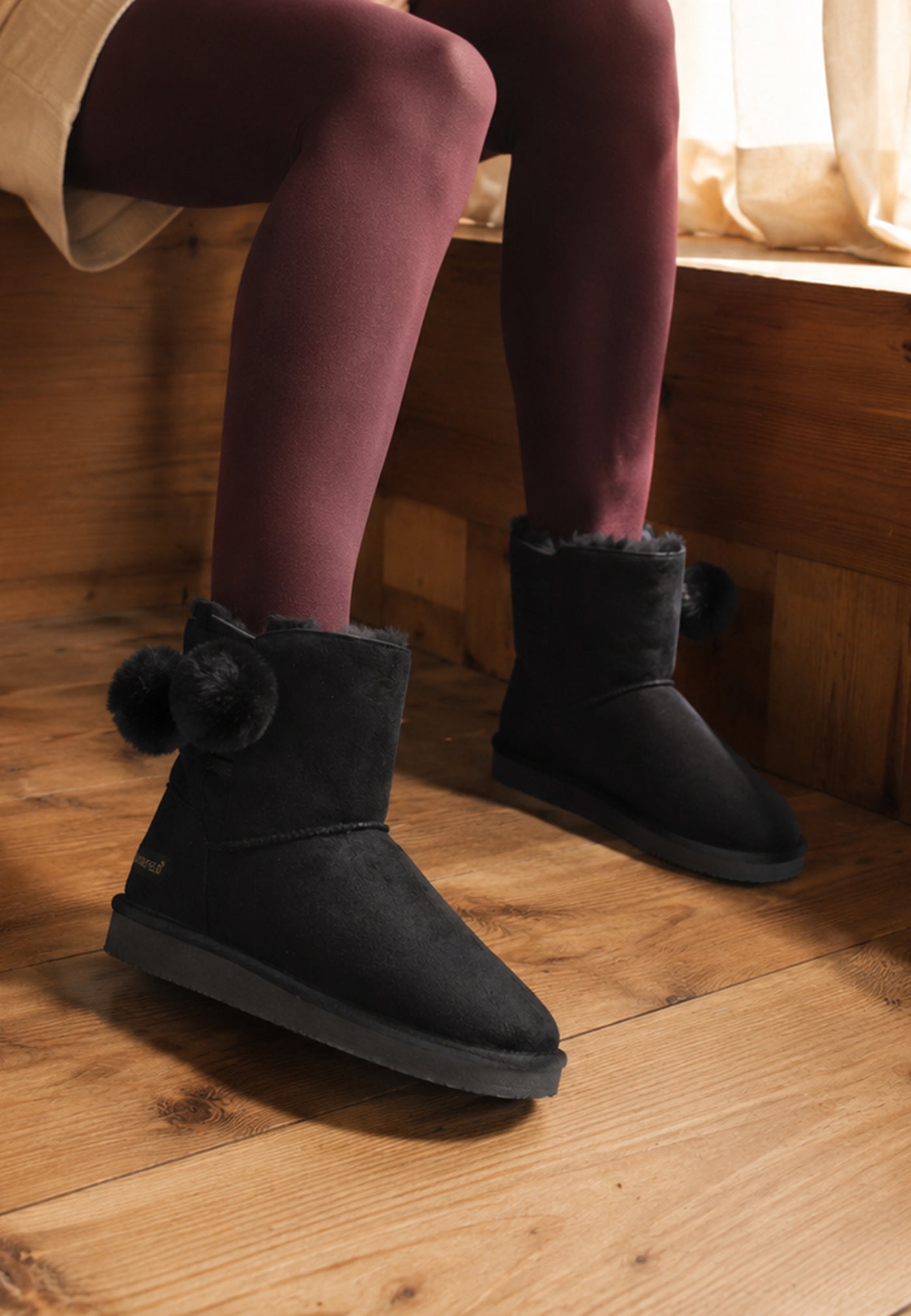 Bottines fourrées Winnipeg noires portées assise, collants bordeaux et parquet