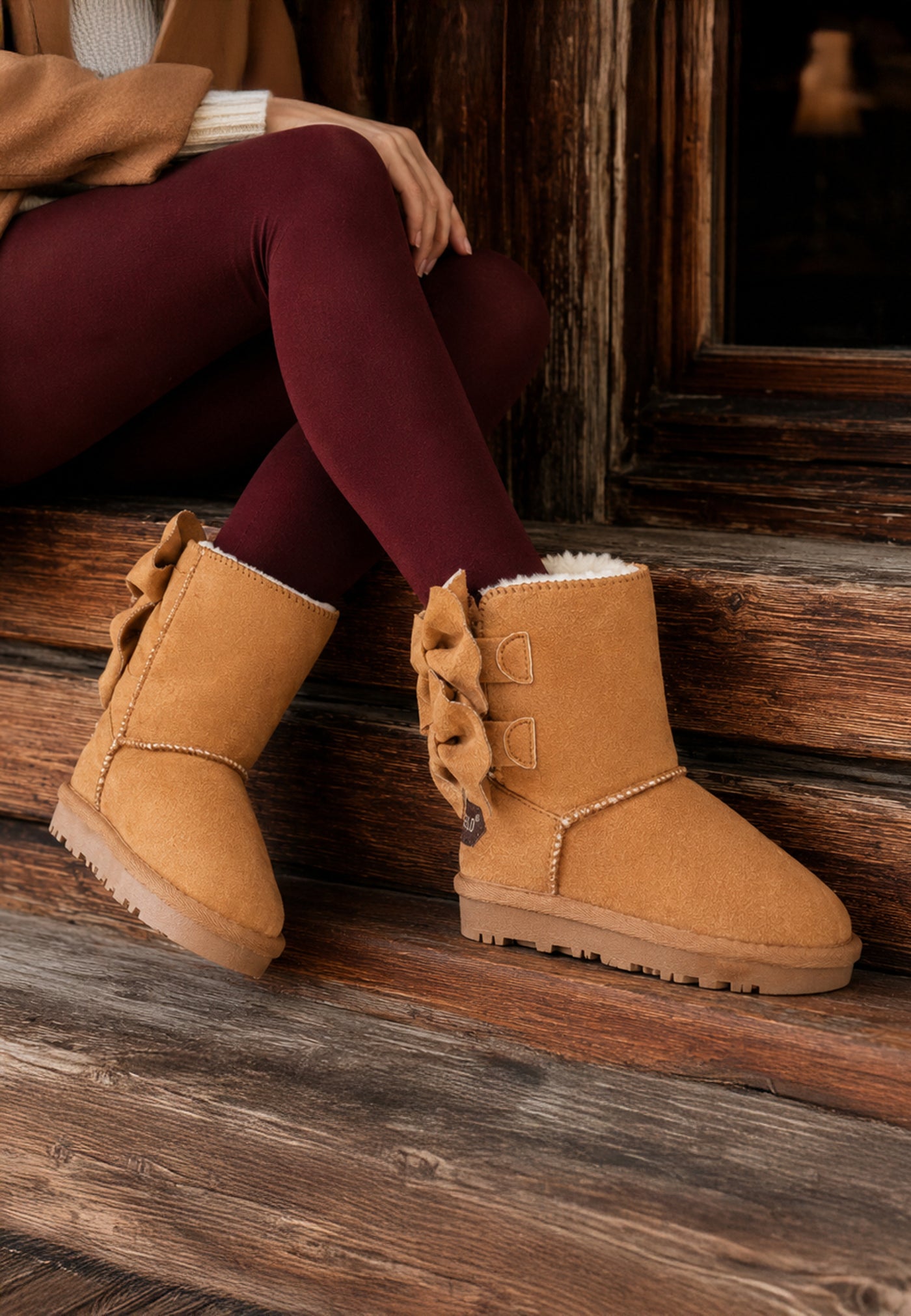 Bottines fourrées Belezza camel portées devant un chalet avec des leggings bordeaux
